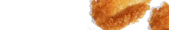 A close-up of Brown Sugar Exfoliant smeared on a white background